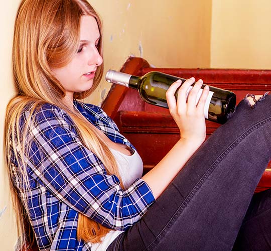 девушка сидит на лестнице с бутылкой вина